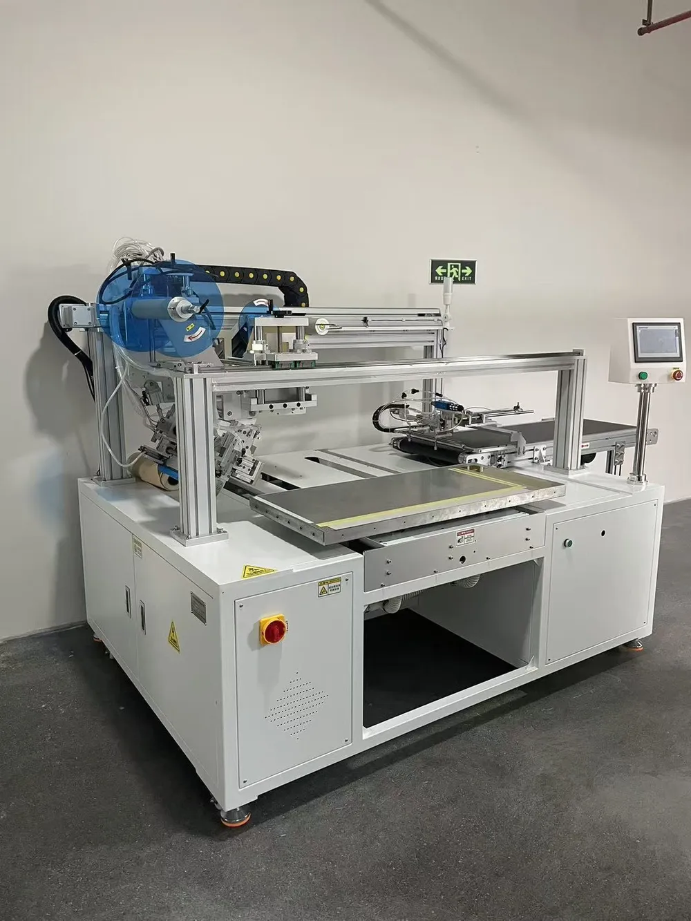 Custom Wide-Format Tape Applicator with Outfeed Conveyor — Gantry and tape head above the fixture table