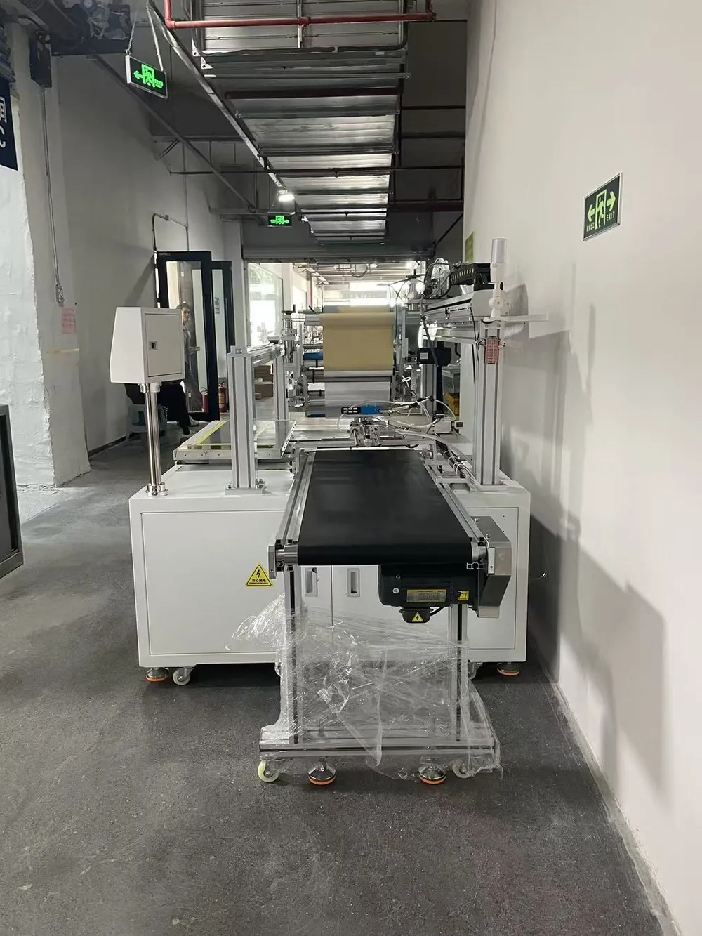 Custom Wide-Format Tape Applicator with Outfeed Conveyor — End view with the outfeed conveyor