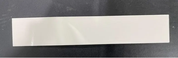Inline Conveyor Tape Applicator — Flat strip-shaped part with tape applied