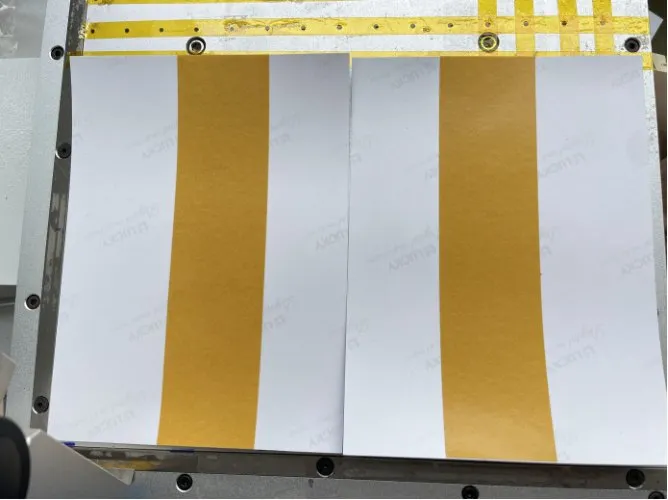 Desktop Tape Applicator — High-temperature tape strips applied on white sheets